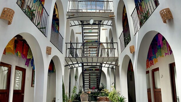 Ein geräumiger Atrium mit hoher Decke, mehreren Balkonen und einer zentralen Treppe.