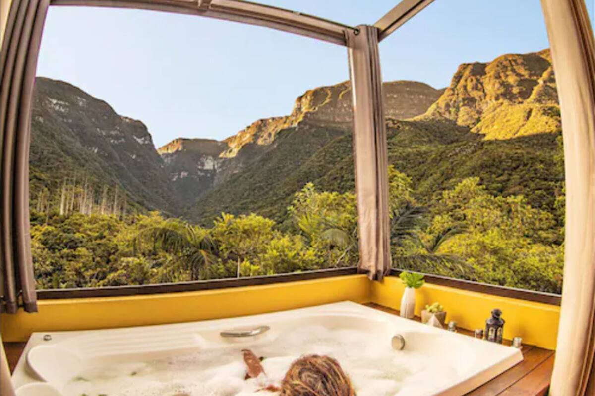 Una habitación con un gran ventanal con vistas a un paisaje montañoso.