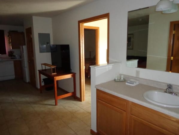Una cocina con una mesa de madera, un fregadero y armarios.