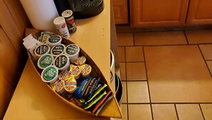 A kitchen with a microwave, coffee maker, and a shelf with jars of condiments. - Kenosha Lodge (Grant)