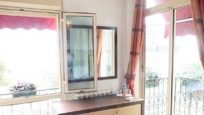 A room with a wooden desk, a mirror, and a radiator. - Telemly Hotel (Algiers)