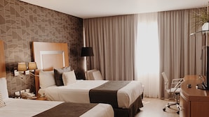 A hotel room with two beds, a desk, a chair, a lamp, and a television. - Hotel Mercury Inn (Querétaro)