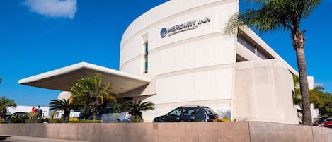 A modern building with a curved facade and a prominent overhang, labeled 'Mercury Inn'.