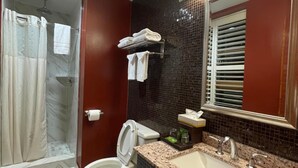 A modern bathroom with a toilet, sink, and shower area. - The Architect (Washington)