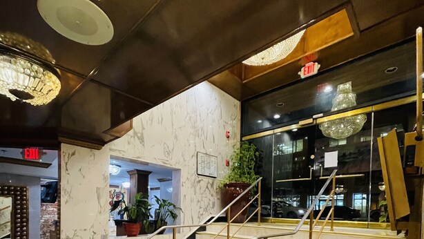 A marble staircase with golden railings leading to an upper floor. - The Architect (Washington)
