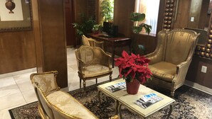 A lobby with a sofa, armchairs, a coffee table, and a potted plant. - The Architect (Washington)