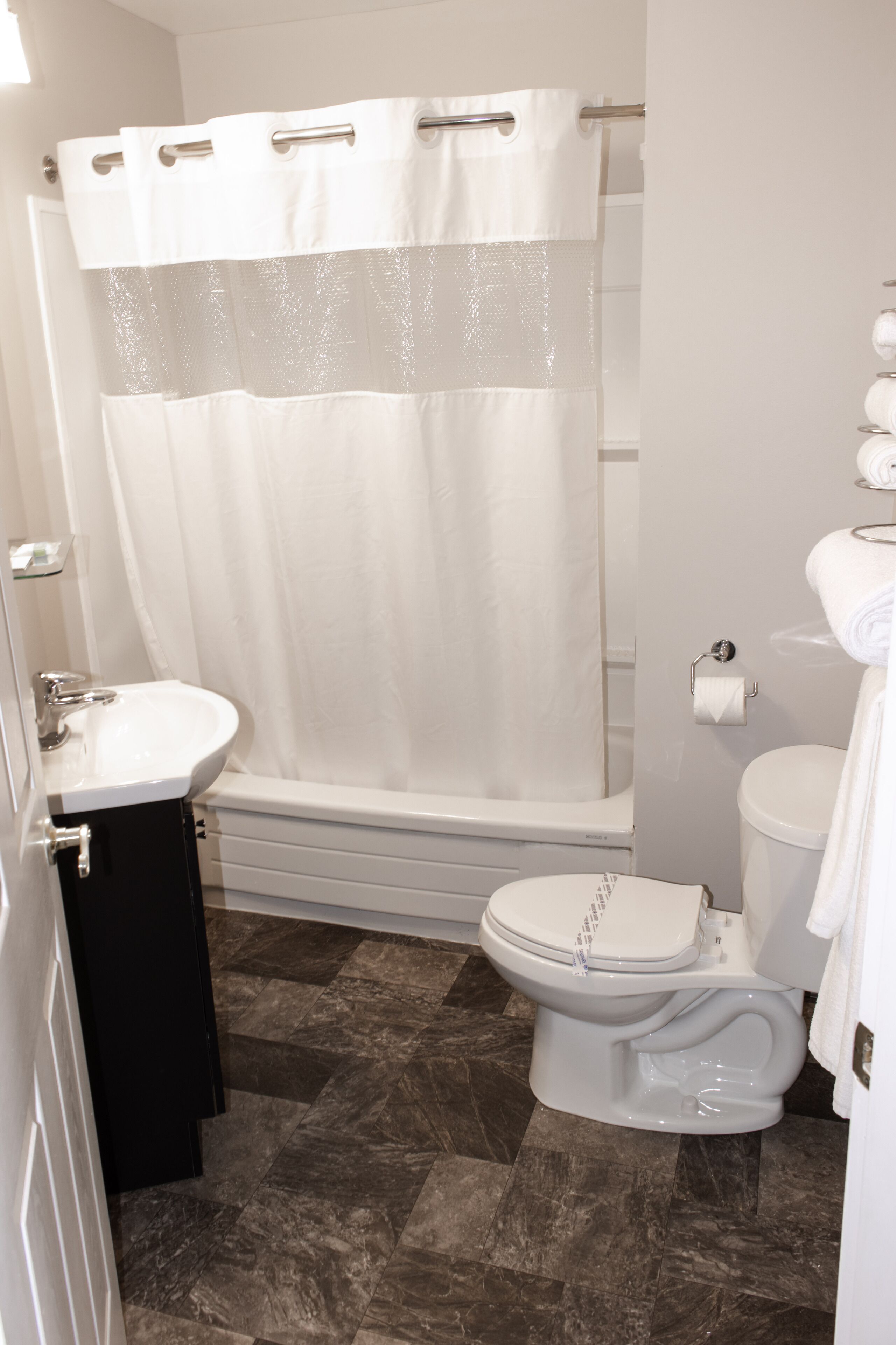 A bathroom with a shower, toilet, and sink.