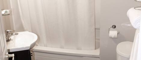 A bathroom with a shower, toilet, and sink.