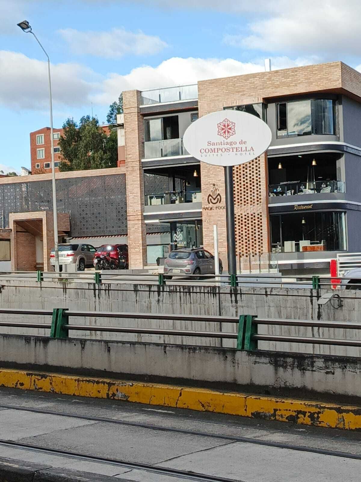 Un hotel moderno con un cartello che indica 'Santiago de Compostela Hotel Suites - Hotel'.