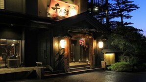A traditional Japanese building with a wooden facade, a large illuminated sign, and a staircase leading to the entrance. - Kutsurogijuku Chiyotaki (Aizuwakamatsu)