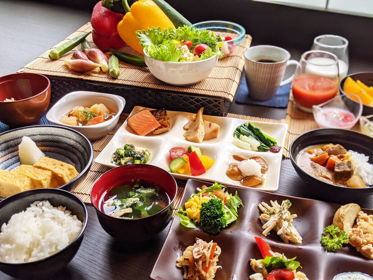 Une variété de plats japonais, notamment des sushis, des sashimis et des tempuras, présentés sur une table avec des bols et des assiettes.