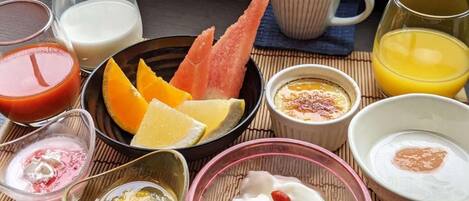 A breakfast setting with various food items and drinks on a table.