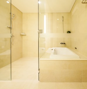 A modern bathroom with a glass-enclosed shower, a separate bathtub, and tiled walls. - Hotel The Born Jeju (Seogwipo)