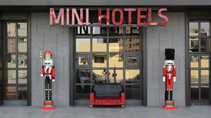 A building with a sign reading "MINI HOTELS" and two nutcracker statues in front. - Mini Hotels Feng Jia Branch (Taichung)