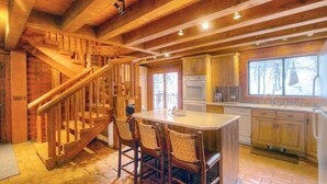 Un interno in legno con una scala, una cucina e un'area pranzo.