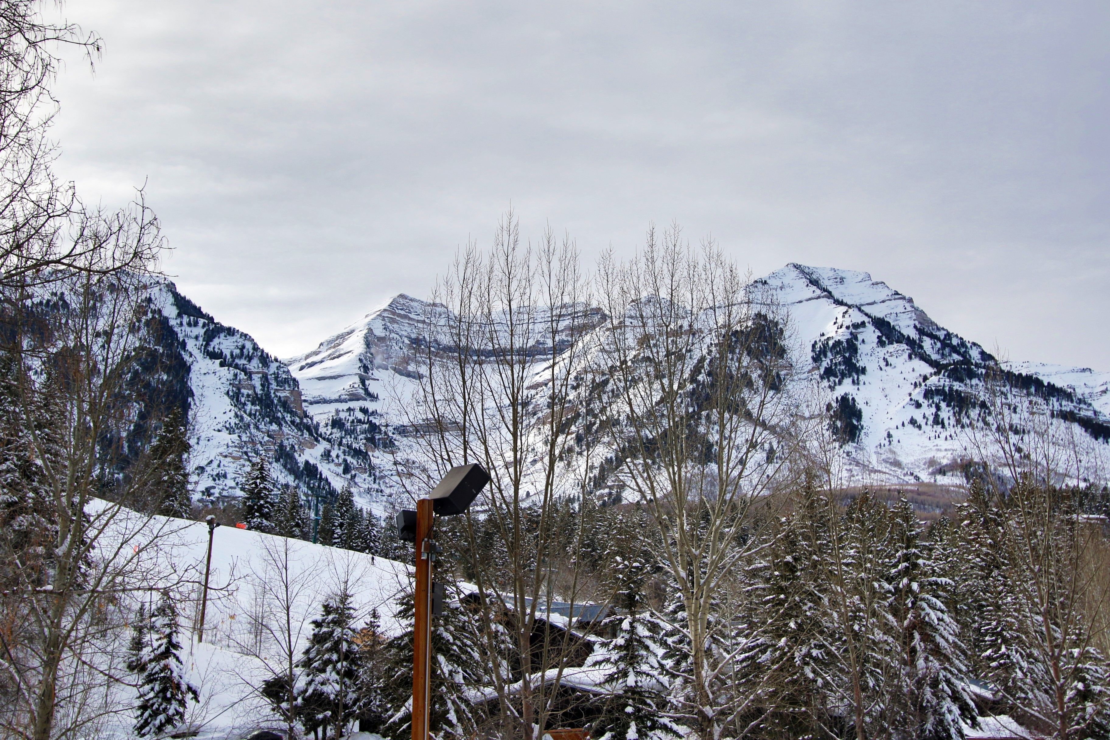 A snow-covered mountain landscape with a wooden structure in the foreground.