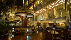 A spacious lobby with a central coffee station, seating areas, and a modern architectural design. - Classic Hotel (Jakarta)