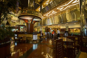 A spacious lobby with a central coffee station, seating areas, and a modern architectural design.