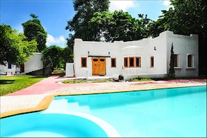 A white building with a pool in front.