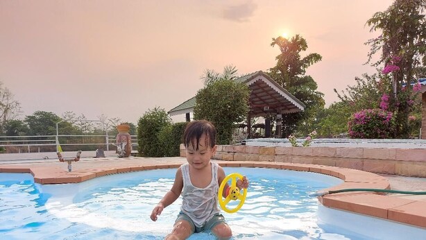 Un niño en una piscina con un juguete amarillo.