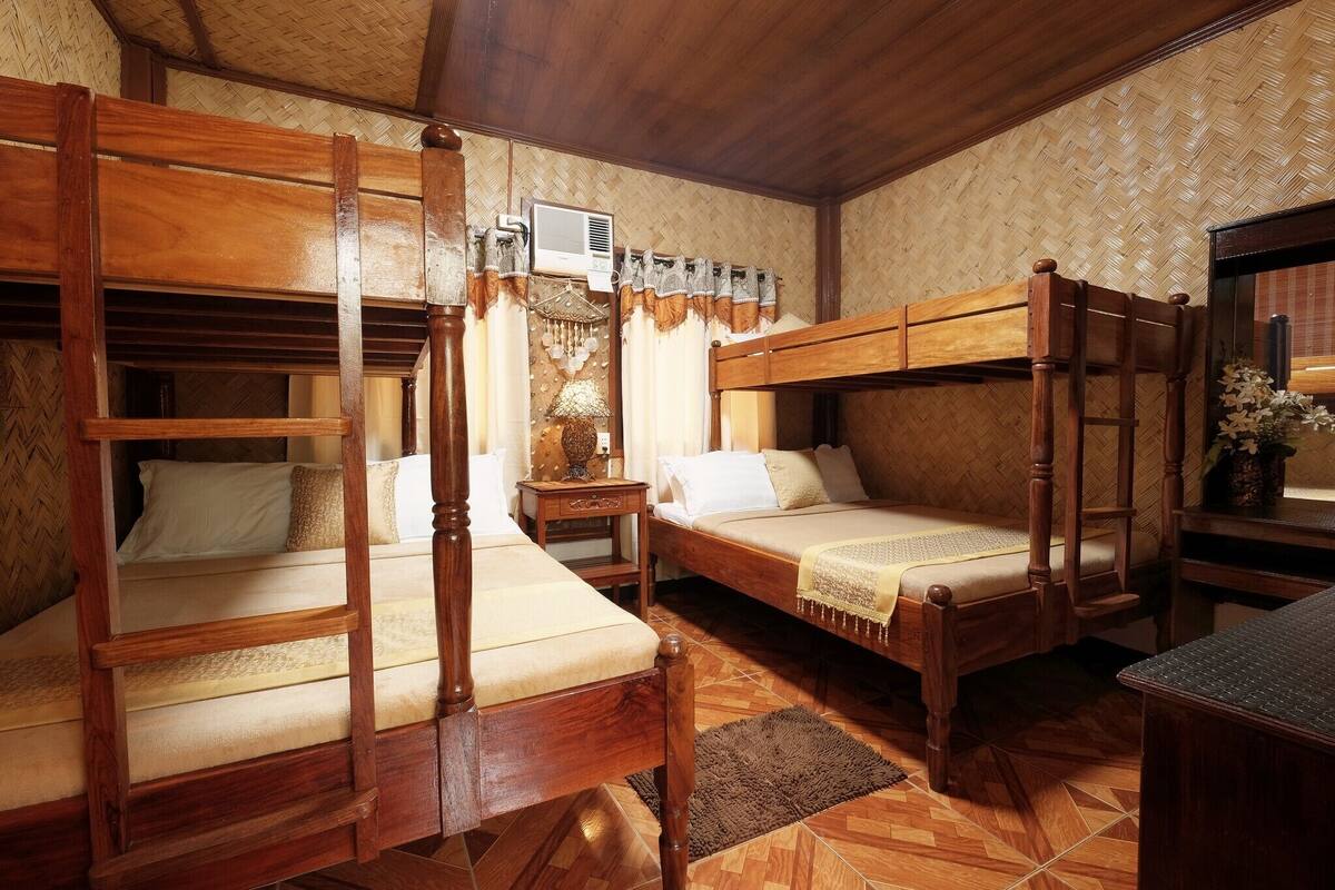 A traditional room with wooden bunk beds, a small table, and a lamp.