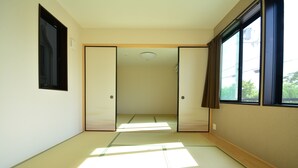 A room with tatami flooring, sliding doors, a window with curtains, and a ceiling light. - Shukusai Art stay in Tofukuji (Kyoto)