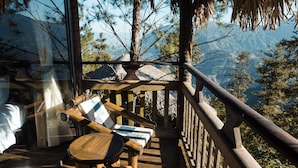 A wooden deck with a table and chairs, overlooking a mountainous landscape. - Sapa Jade Hill Resort & Spa (Sa Pa)