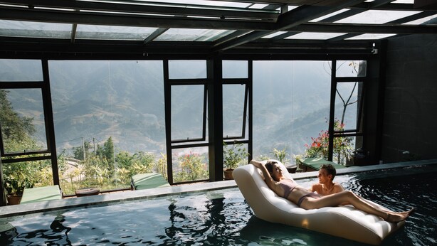 A pool with a view of mountains, a glass ceiling, and a lounge chair. - Sapa Jade Hill Resort & Spa (Sa Pa)