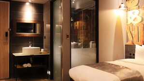 Une salle de bain moderne avec un grand miroir, un lavabo et une douche.