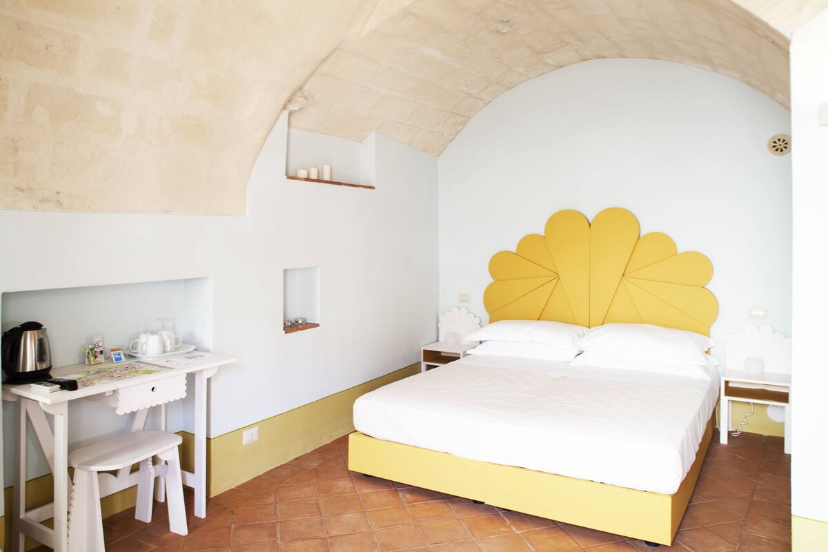 A room with a bed, a desk, and a chair.