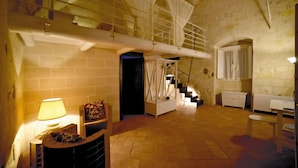 Um quarto amplo com teto alto, escada e cama.