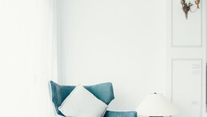 A modern room with a blue armchair, a white table, and a lamp. - Zai Yan-Yan B&B (Ji'an)