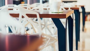 A row of white chairs with wooden tables, each with a white cup and a green napkin. - Zai Yan-Yan B&B (Ji'an)