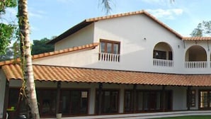 Edifici de dues plantes amb un pati interior, amb teulada de rajoles, finestres apuntades i un balcó.
