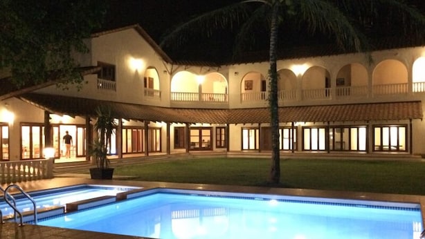 Un hotel amb piscina, zona exterior coberta i diversos balcons.