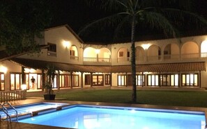 A hotel with a swimming pool, a covered outdoor area, and multiple balconies. - Casa Titik (Cherating)