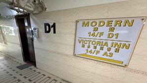 Una estación de metro con un cartel que indica el Modern Victoria Inn en el piso 14, accesible por el ascensor D1.