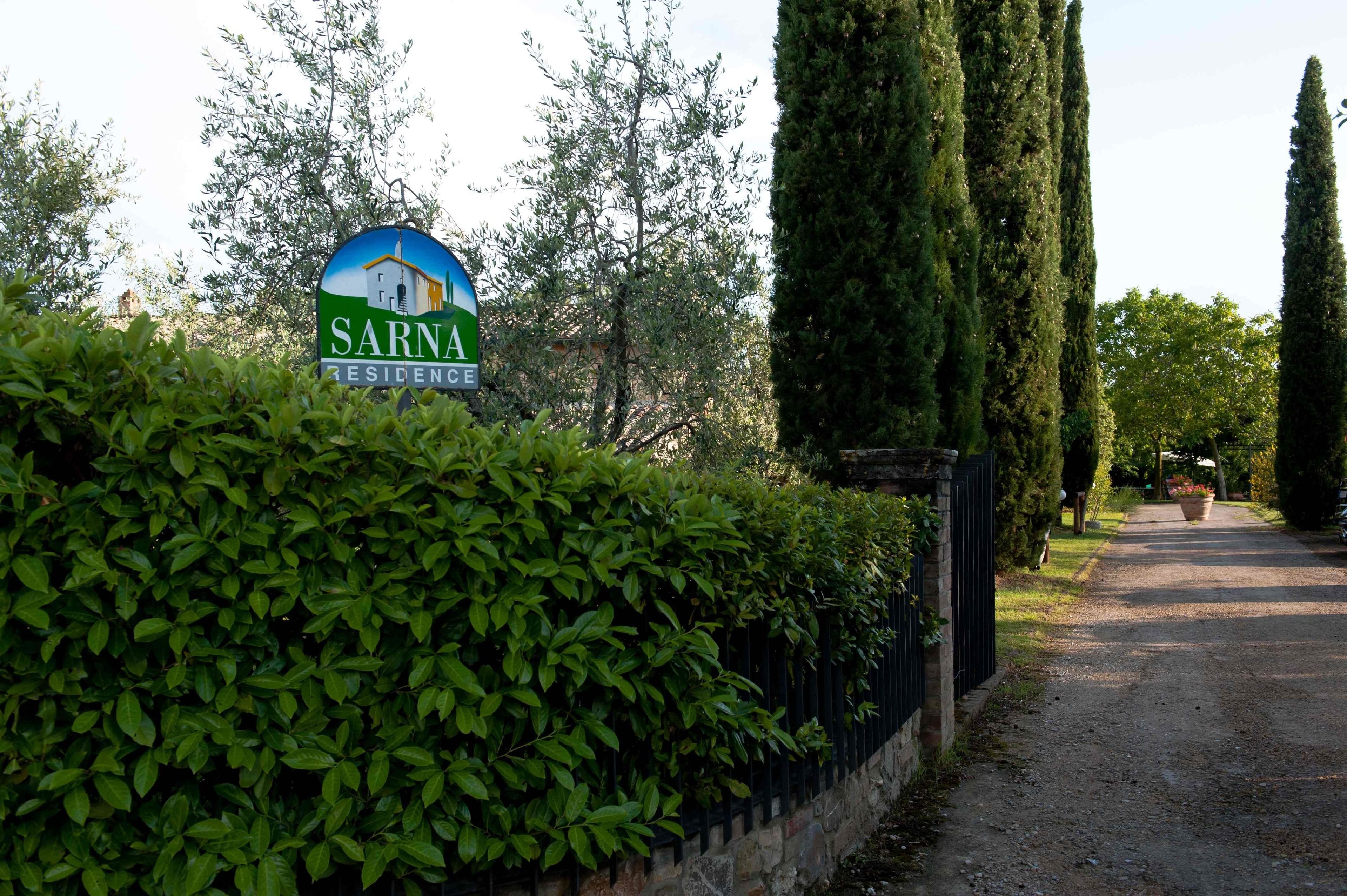 Indicador de 'Sarna Residence' amb un camí cap a una zona tancada per una reixa.