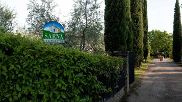 Indicador de 'Sarna Residence' amb un camí cap a una zona tancada per una reixa.