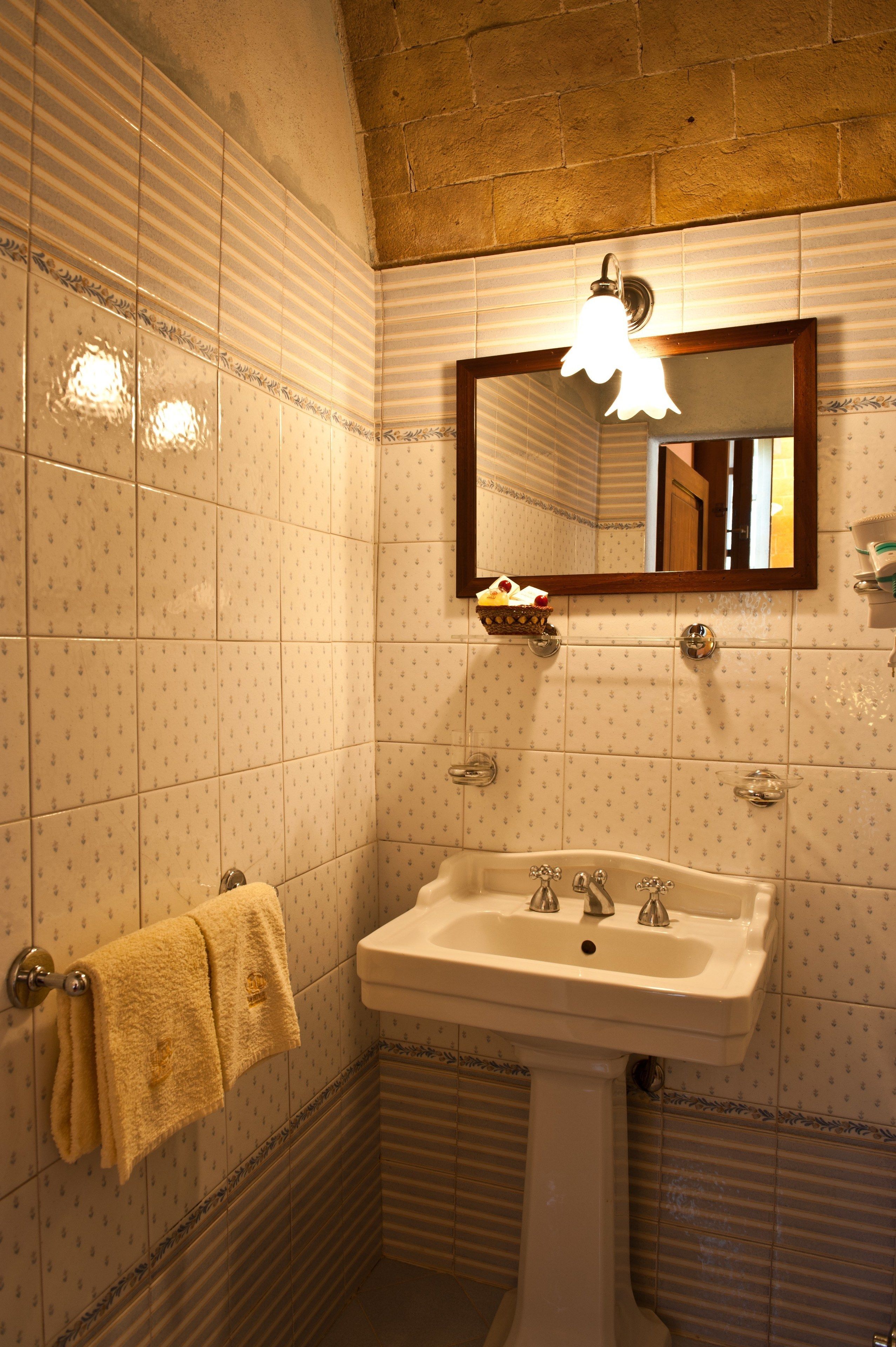 A bathroom with a sink, mirror, and towel rack.