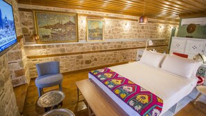 A cozy room with a bed, a chair, a table, and a wall-mounted TV. - Charme Hotel (Antalya)