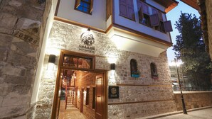 A stone building with a sign reading "CHAR ME" and a staircase leading to an upper level. - Charme Hotel (Antalya)