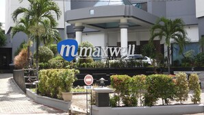 Ein modernes Gebäude mit einem Schild für das Maxwell Hotel.