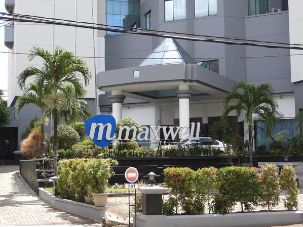Un bâtiment moderne avec une enseigne indiquant « Maxwell Hotel ».