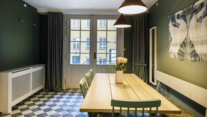 A dining area with a checkered floor, a wooden table, and chairs. - Churchill 3BR by Daniel&Jacob's (Copenhagen)