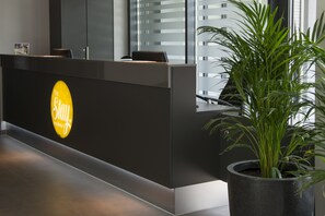Una recepción con un cartel que dice 'Stay', una planta en maceta y un diseño de interiores moderno.