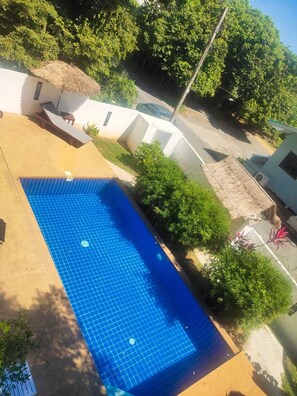 A rectangular swimming pool with a blue tiled surface, surrounded by a concrete deck. - BEA Apartment (Koh Samui)