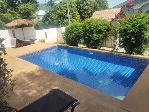 A rectangular swimming pool with blue tiles, surrounded by a concrete deck. - BEA Apartment (Koh Samui)