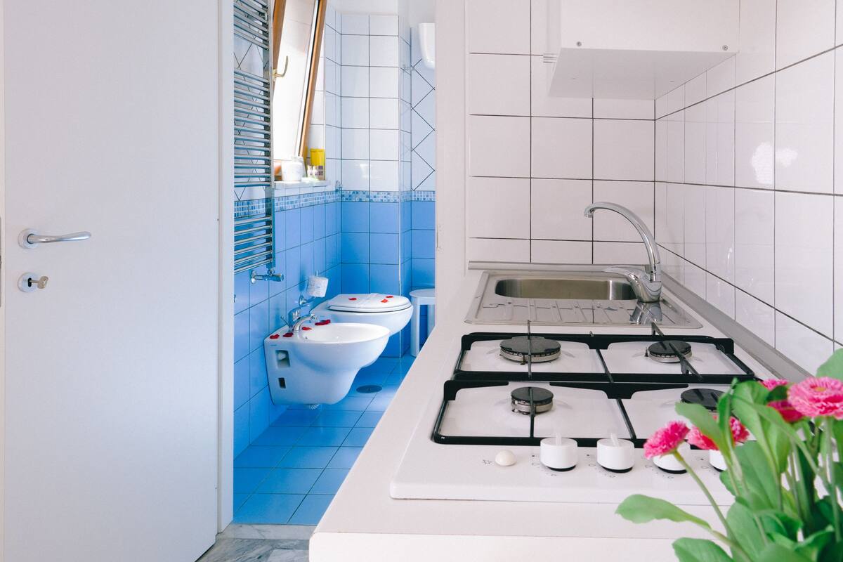 A modern kitchen with white countertops, a gas stove, and a sink.