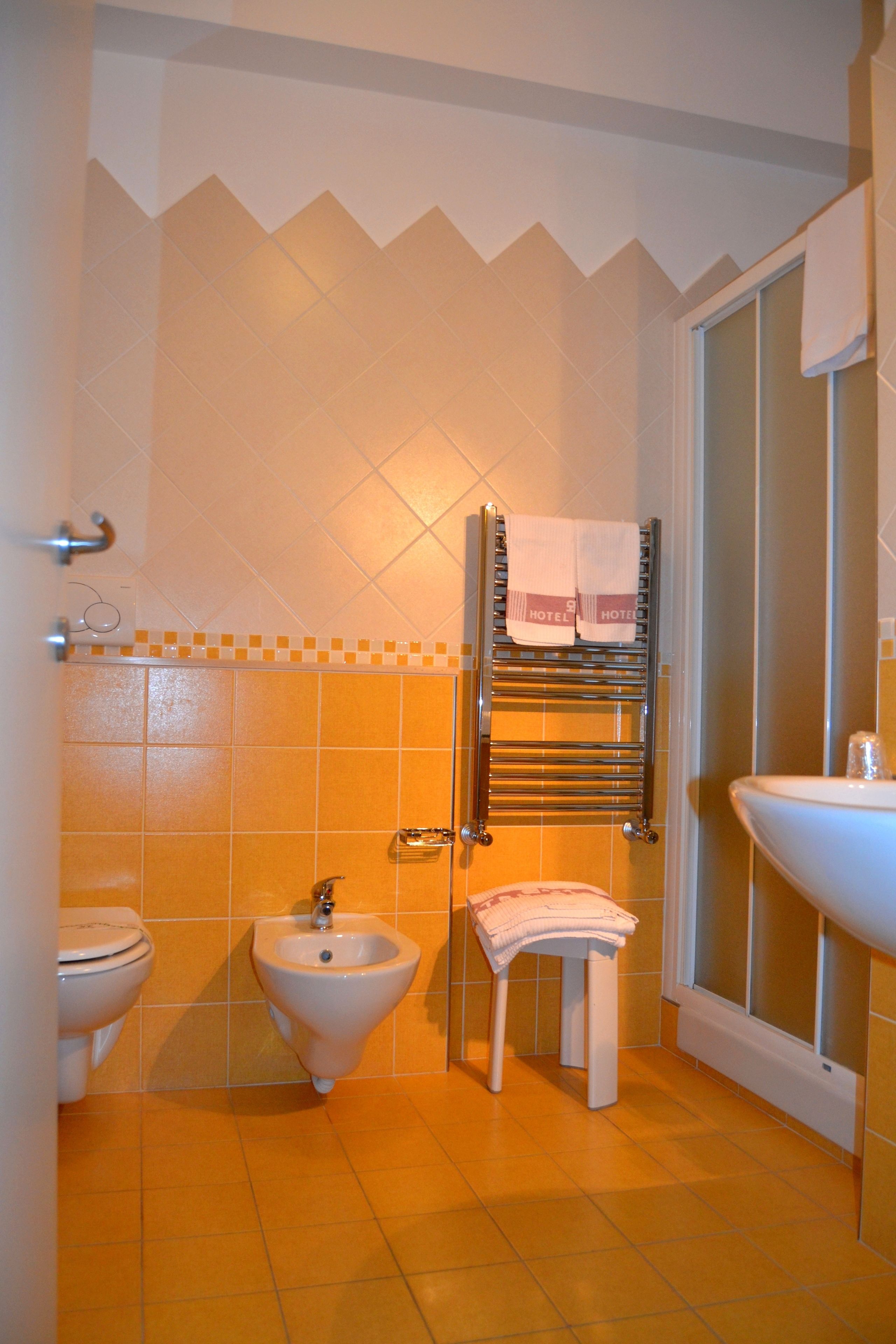 Ein Badezimmer mit Bidet, Toilette und Waschbecken.